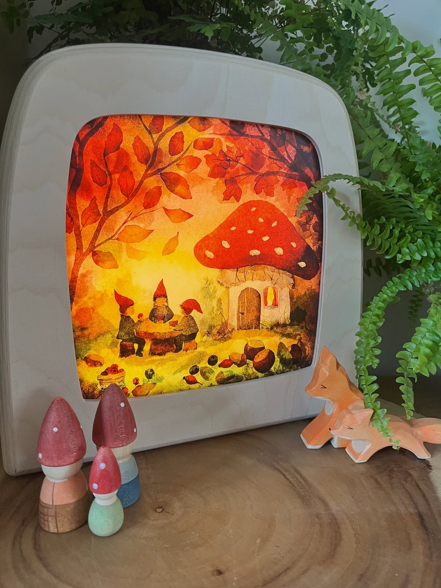 Toverlux light with a mushroom and gnome design, surrounded by small wooden figures and plants.